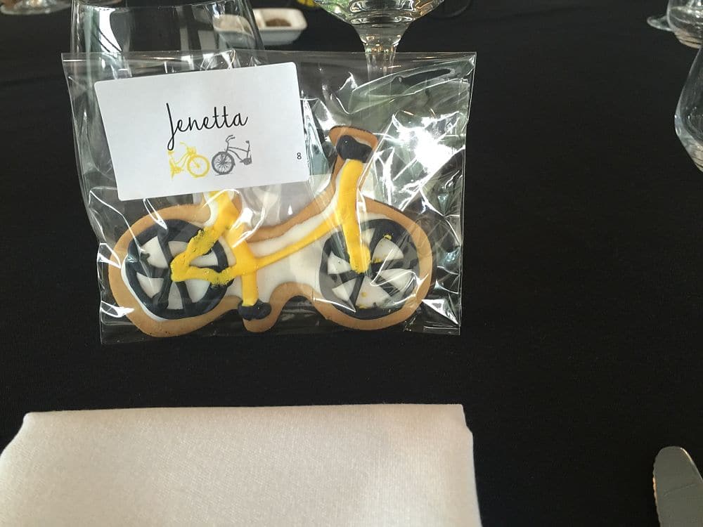 Wedding favours a yellow and black cookie in the shape of a bicycle wrapped in cellophane