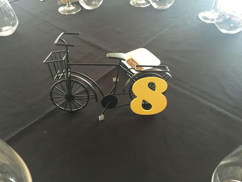 Close up of table decoration - small black metallic bicycle table number 8