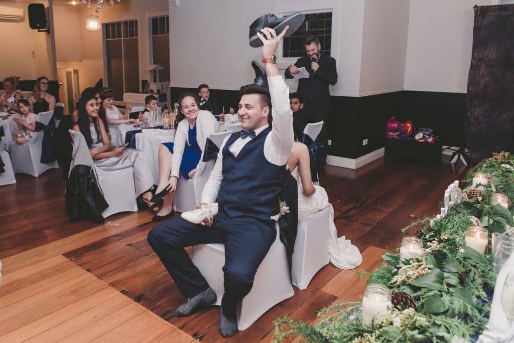 Bride and Groom Playing The Shoe Game conducted by DJ Scott with all their guests watching and laughing seated in the cellar room at Windy Ridge Ohaupo