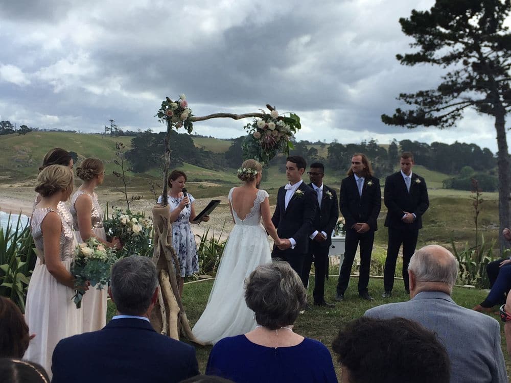 Orua Beach House - Wedding ceremony featuring celebrant and bridal party on top of cliff overlooking hot water beach
