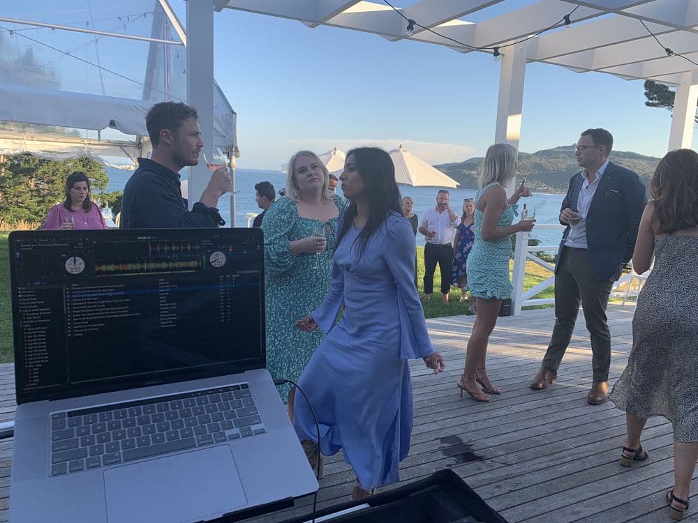 Orua Beach House - Wedding guests drinking and dancing on deck in the early evening