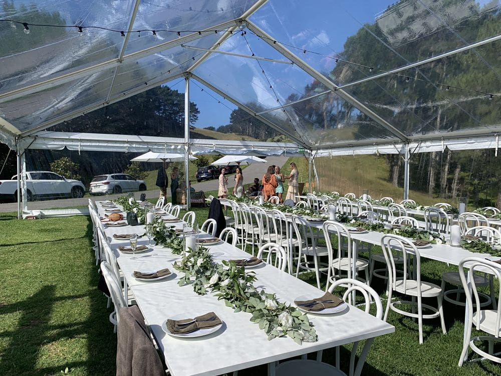 Orua Beach House - Wedding reception banquet tables set up in marquee