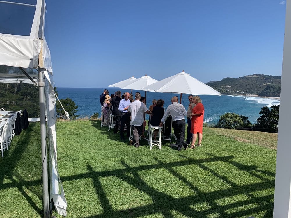 Orua Beach House - Guests standing under umbrellas whilst enjoying the panoramic views